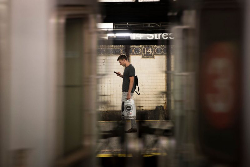 uomo in metropolitana con smartphone