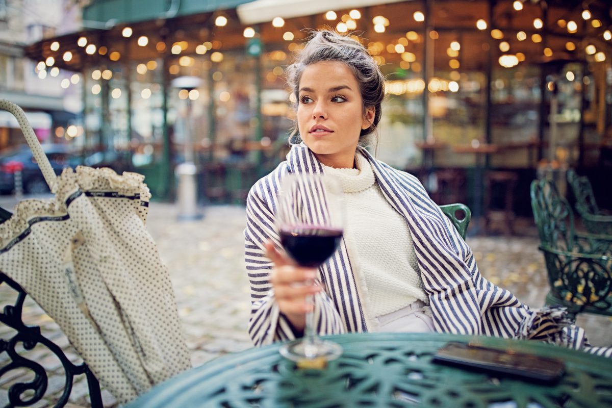 donna beve vino in un bistrot