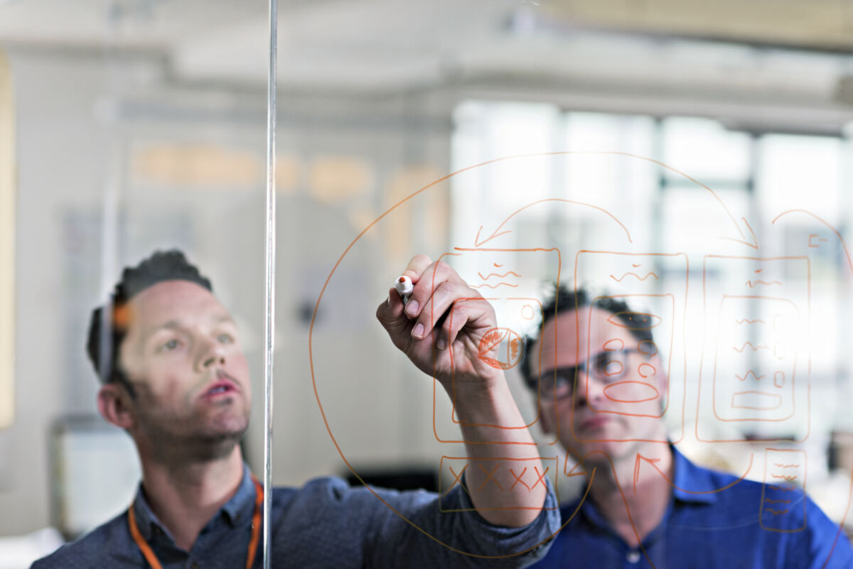 Businessman drawing diagram on glass wall in tech start-up office - Errore