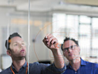 Businessman drawing diagram on glass wall in tech start-up office - Errore